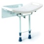 Wall-mounted shower seat with feet resting on the floor
